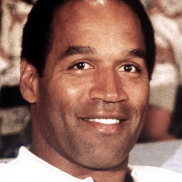 A image of NFL Football Legend OJ Simpson Smiling with a white T-Shirt on.