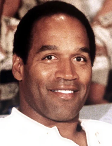 A image of NFL Football Legend OJ Simpson Smiling with a white T-Shirt on.