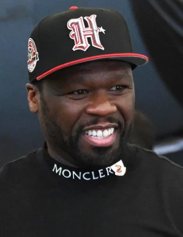 A image of Celebrity rapper and filmmaker 50 Cent at Barksdale AFB in a black and red hat and black shirt.